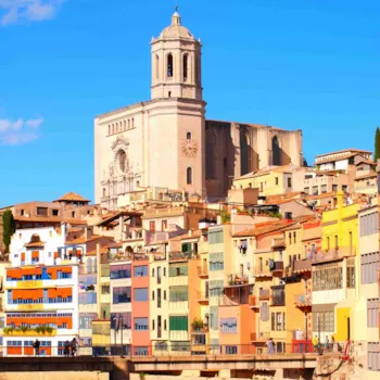 Blick auf die bunten Häuserfassaden am Fluss Onyar mit im Hintergrund der Kathedrale von Girona