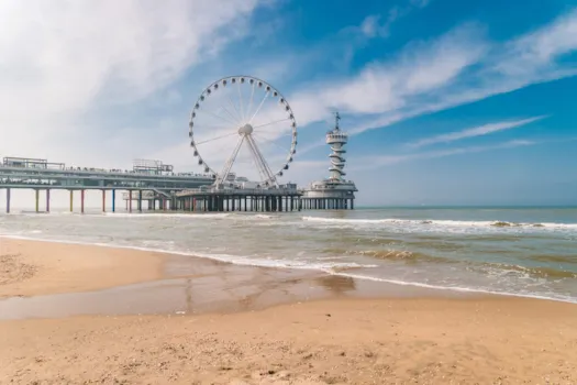 Strand von Scheveningen in den Niederlanden im Frühling, das Riesenrad auf der Seebrücke von Scheveningen in den Niederlanden, sonniger Frühlingstag am Strand