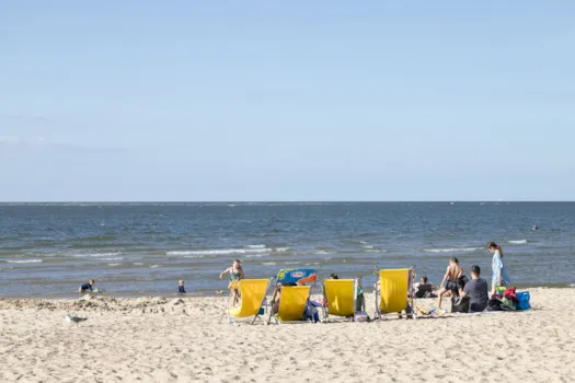 Familie mit Kindern genießt das schöne Wetter am Strand in der Nähe der Touristenstadt Renesse in Zeeland, Niederlande.