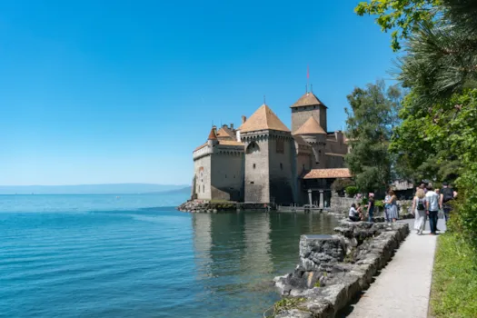 Touristen besichtigen das historische Schloss Chillon am Ufer des Genfer Sees, Schweiz