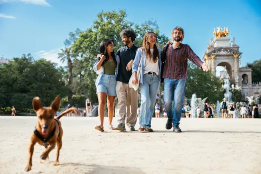 Zwei junge Päarchen enießen einen Spaziergang mit Hund im Parque de María Luisa, Sevilla, Spanien.
