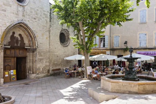Platz in Manosque mit historischem Gebäude und Menschen, die in einem Straßencafé sitzen, Alpes de Haute-Provence, Frankreich