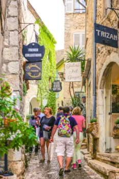 Belebte Gasse in Saint Paul De Vence mit Touristen, die sich die Schaufenster der Galerien anschauen, Provence, France