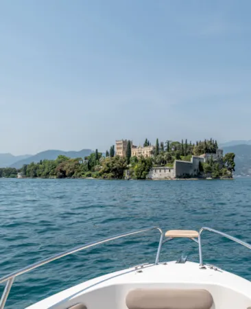 Ein Boot nähert sich der Isola del Garda vom Gardasee aus