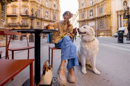 Junge Frau mit ihrem Hund im Straßencafé in Palermo, Sizilien