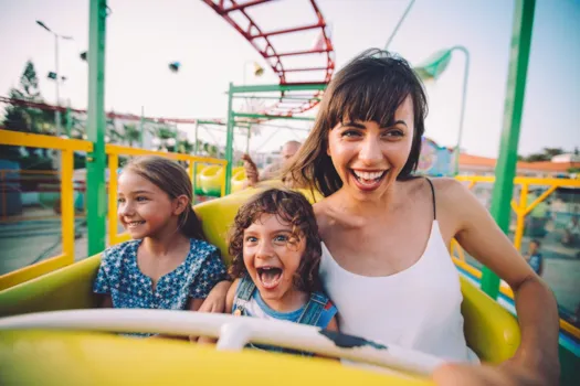 Glückliche Mutter mit Kindern in Achterbahn