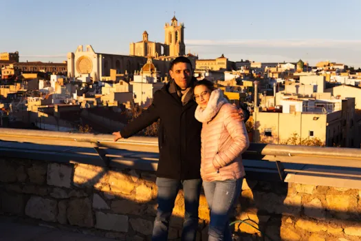 Ein junges Paar posiert für ein Foto mit der Kathedrale von Tarragona im Hintergrund, Spanien