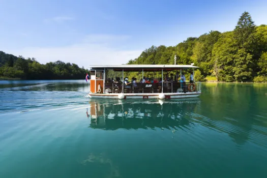 Touristen bei einer Bootsfahrt auf dem Kozjak-See im Nationalpark Plitvicer Seen, Kroatien