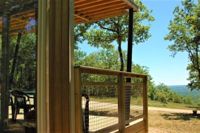 Panoramic chalet, with large bay windows and a view of an ocean of greenery.