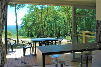 Panoramic chalet, with large bay windows and a view of an ocean of greenery.
