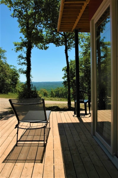 Panoramic chalet, with large bay windows and a view of an ocean of greenery.