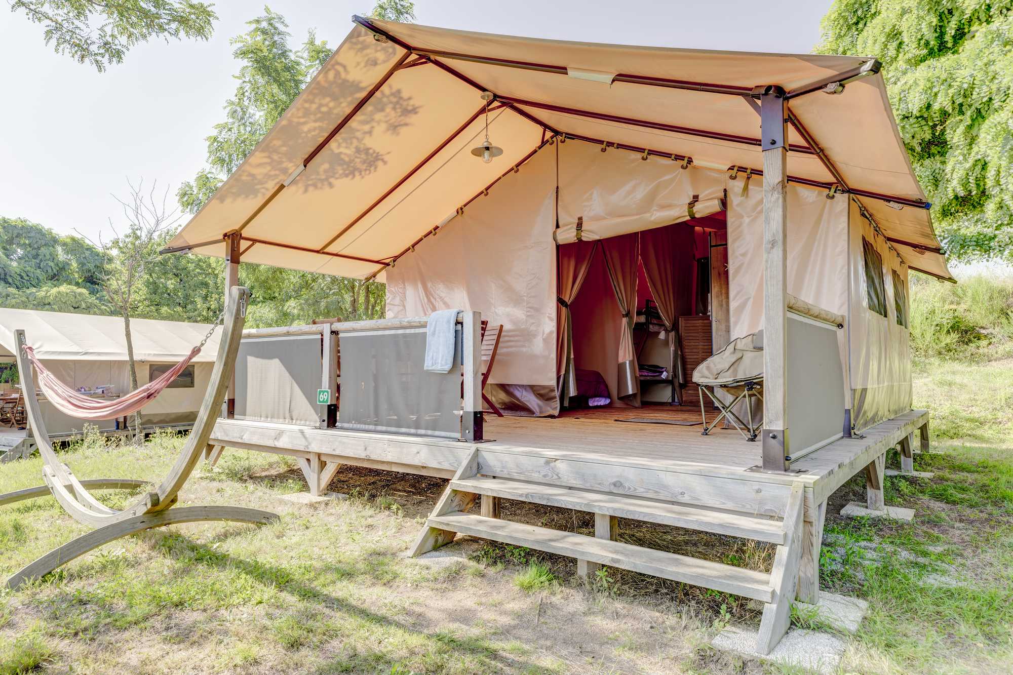 Location - Tente Lodge Victoria  Pour 5 Personnes - 2 Chambres - Salon De Jardin Et Hamac - Avec Sanitaire - Camping Sites et Paysages L'Oasis